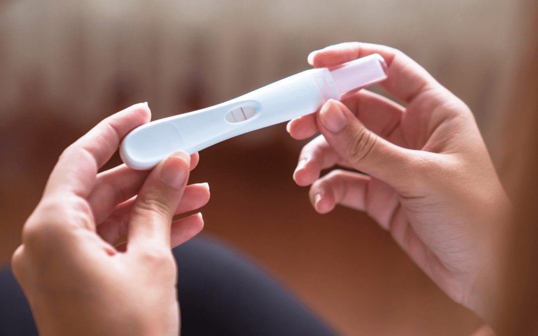 woman holding a pregnancy test